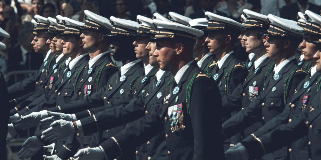 group of dressed service members marching in succession