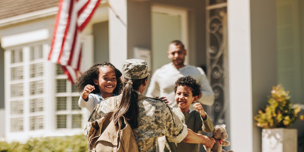 U.S. military veteran hugging family members after returning from deployment