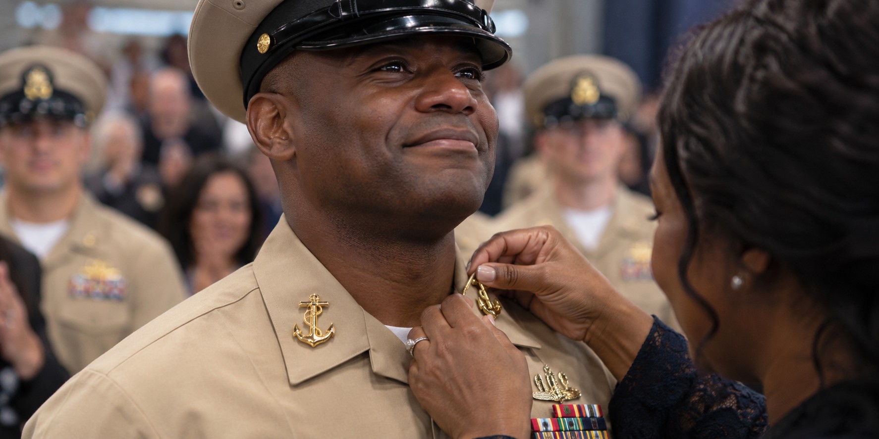 Family member pinning gold anchors during a Navy Chief Petty Officer pinning ceremony
