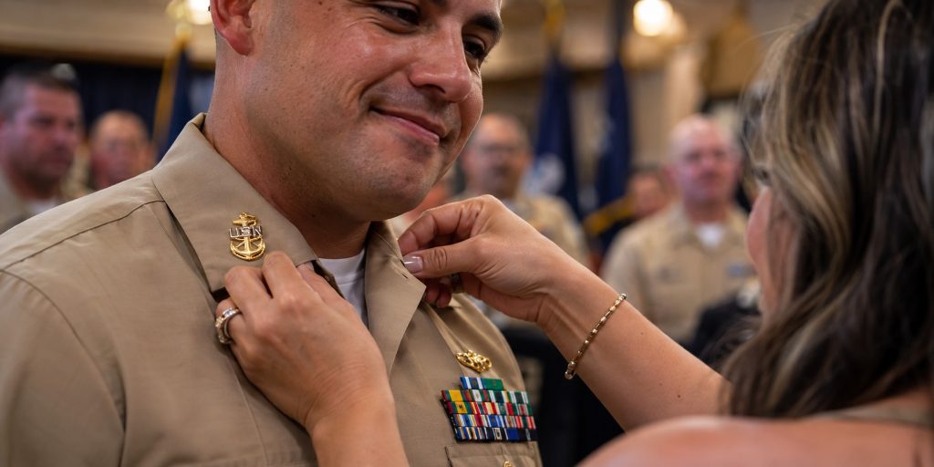 CPO pinning ceremony: family members pin gold anchors on a new Navy Chief Petty Officer's collar